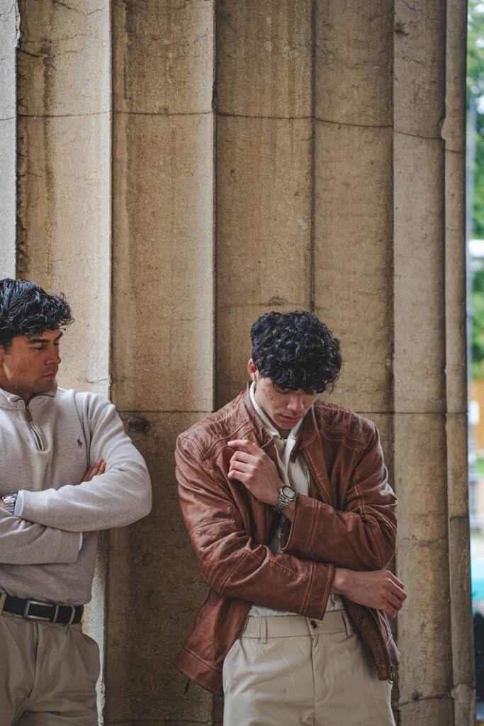 Two fashionable men in Munich, Germany, showcasing modern style and architecture.